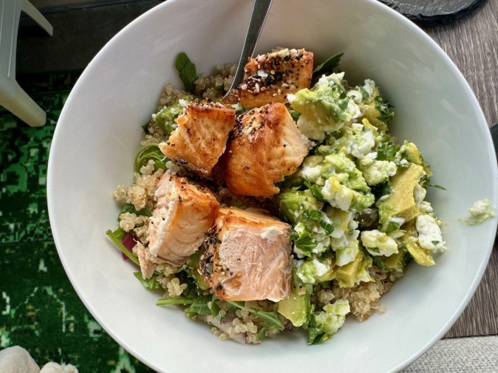 A balanced healthy meal bowl with salmon, grains and greens