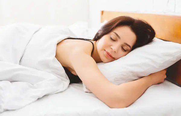 A woman sleeping peacefully in a comfortable bed